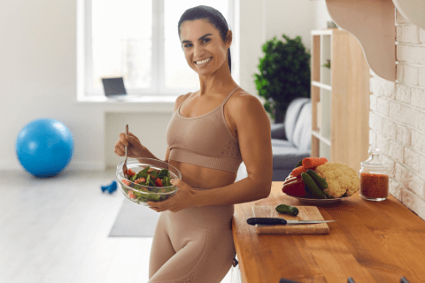 "A fit woman enjoying a plant-based meal, showcasing her commitment to a healthy and plant-forward dietary choice.