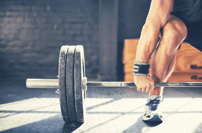 Focused preparation: A determined individual gearing up for a deadlift, embodying concentration and readiness for a powerful lift.